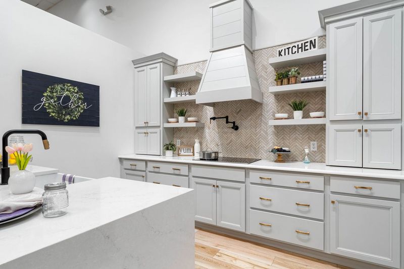 Kitchen with all white cabinets, shelving, countertops and accents