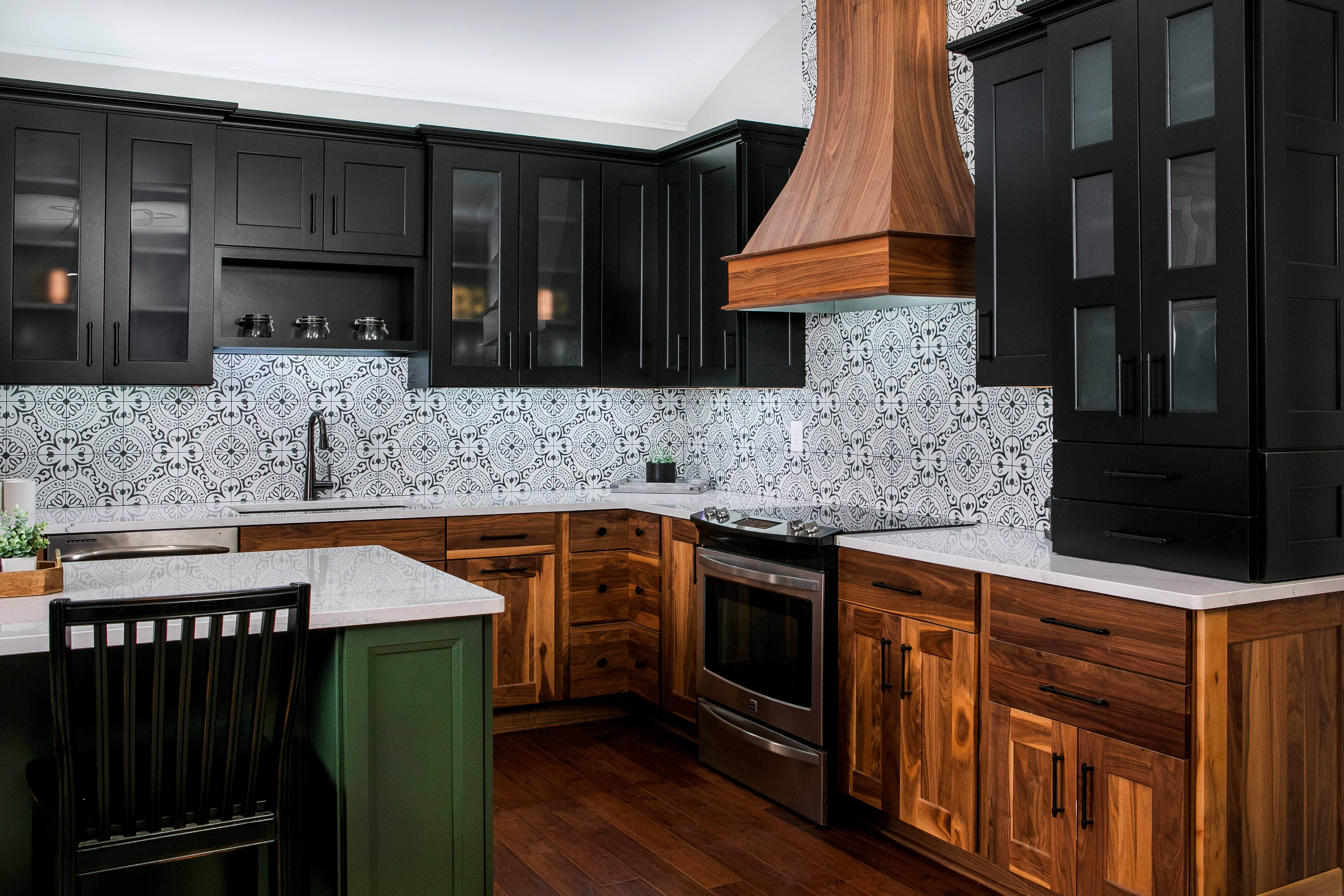 Showroom Display at 84 Lumber of a kitchen with brown wooden cabinets and a large island and wooden hood vent